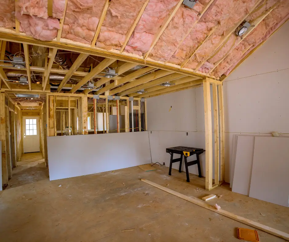 Pink fiberglass insulation installed between ceiling joists in a Virginia Beach home under construction with drywall and ductwork visible