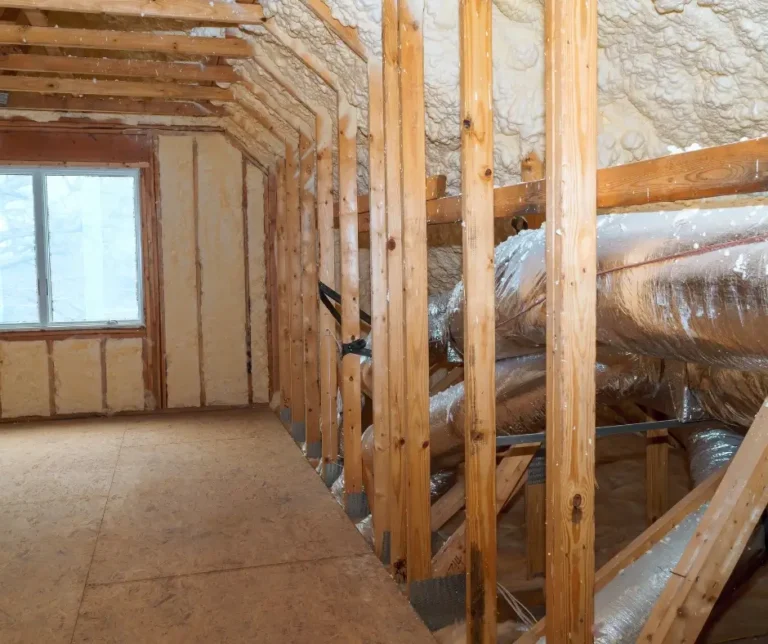 Attic space with spray foam insulation applied to walls and roof deck alongside insulated ductwork and OSB subflooring during Level Up Attic Restoration process